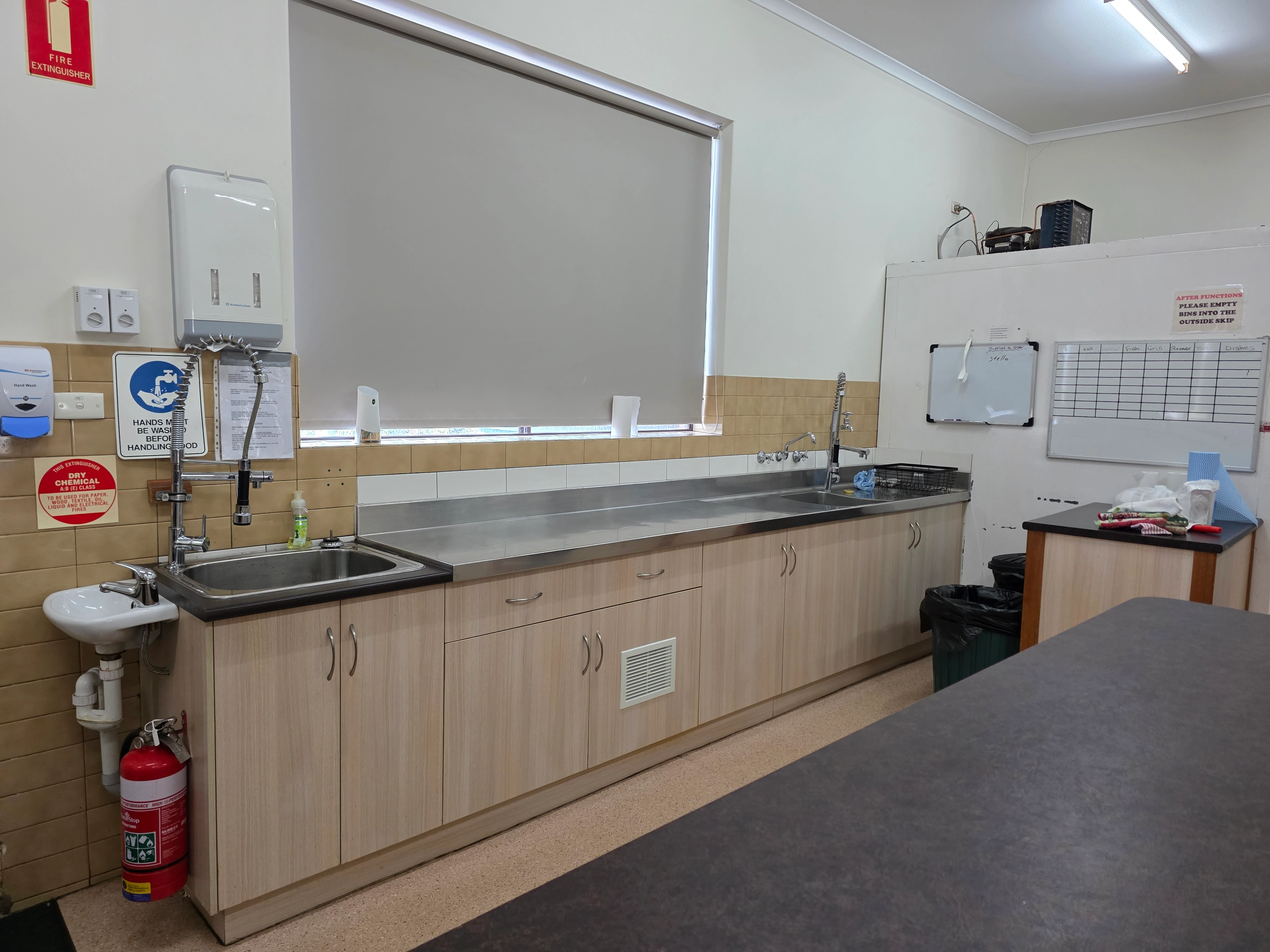 Commercial kitchen with stainless steel benchtops, sinks and food preparation area
