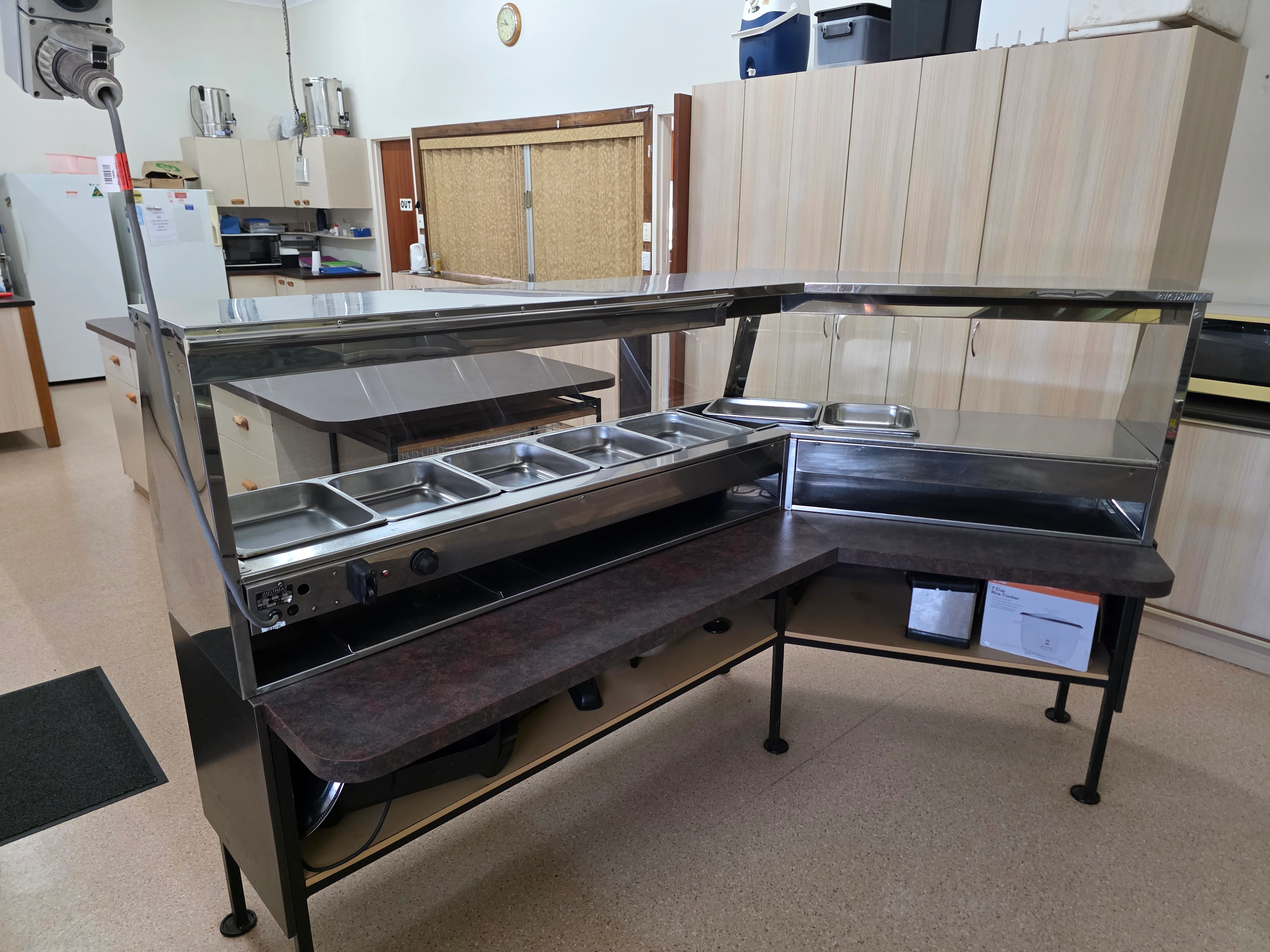 Commercial serving area with stainless steel bain-marie and food service counter